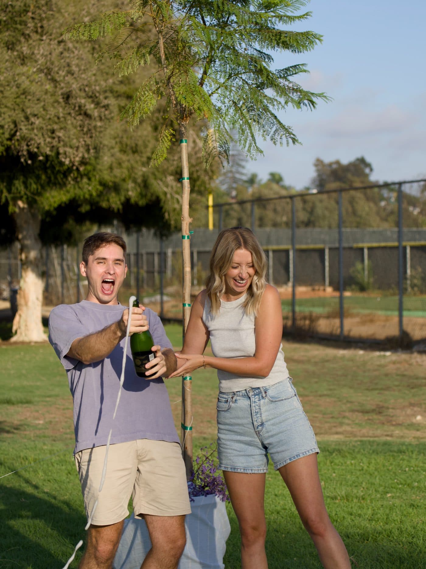 Camille and Zach laughing, the bottle still going